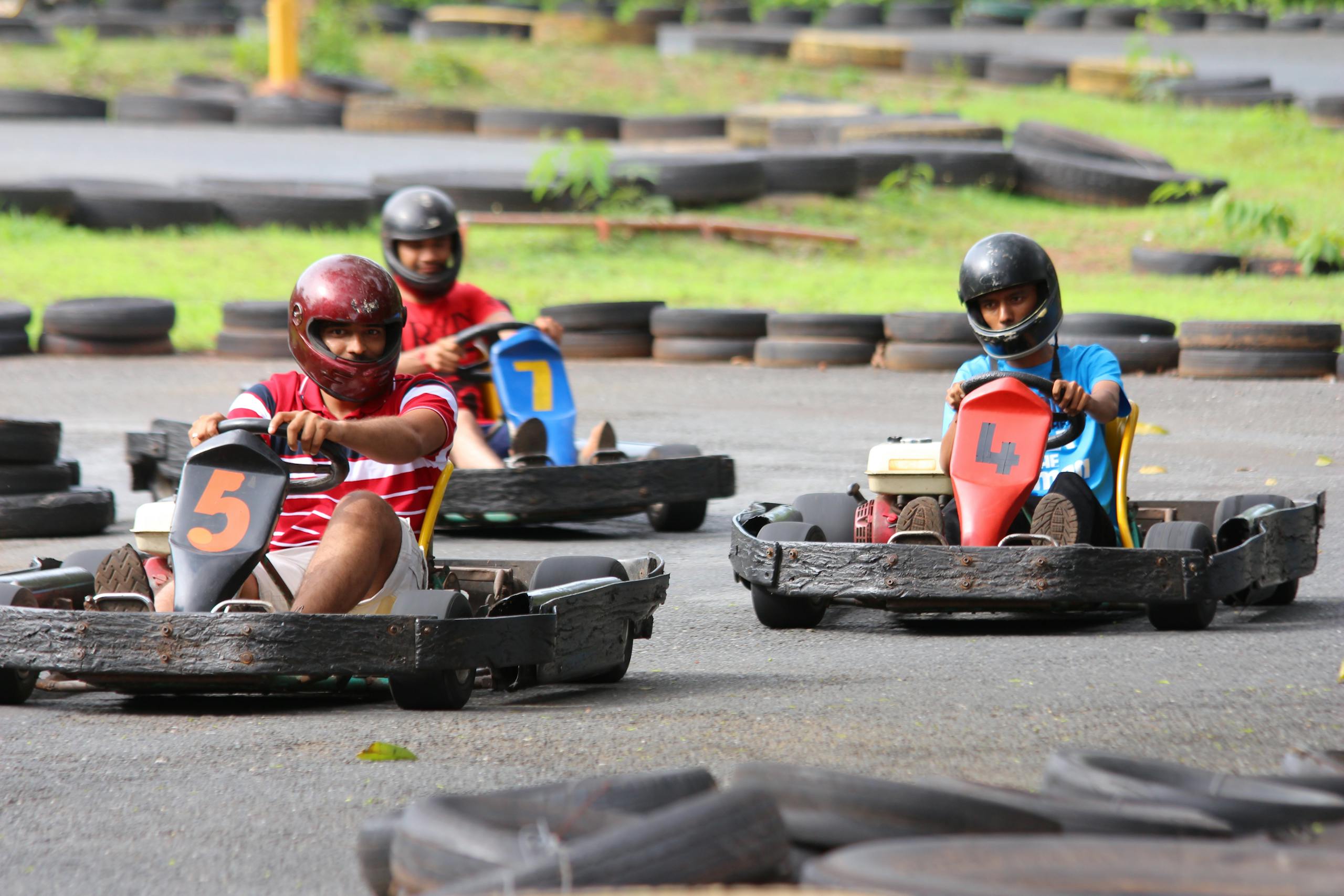 Adults enjoying an exhilarating go-kart race on an outdoor track in Goa, India.